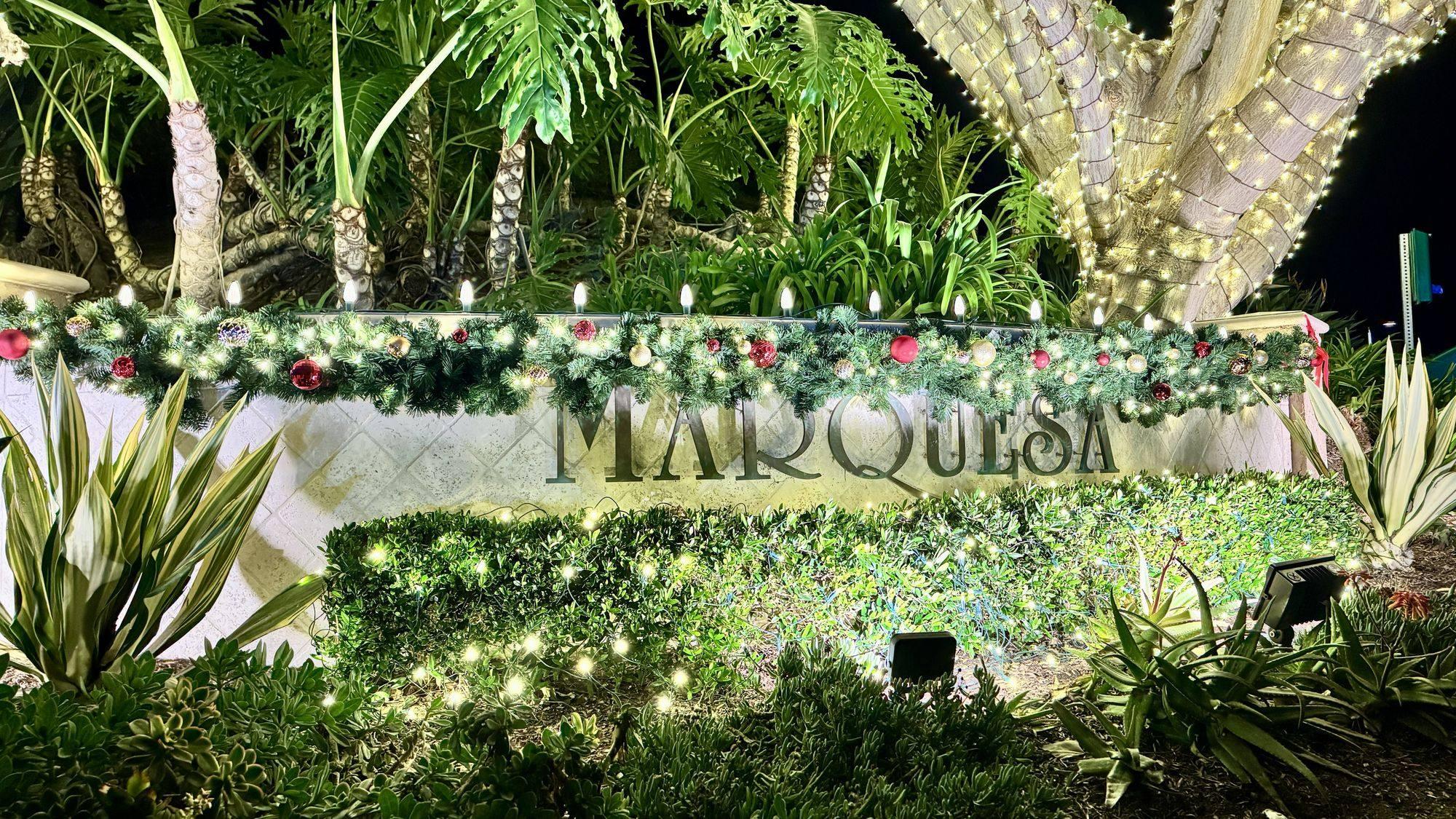 Marquesa entrance sign dressed in evergreen garland and warm white lights